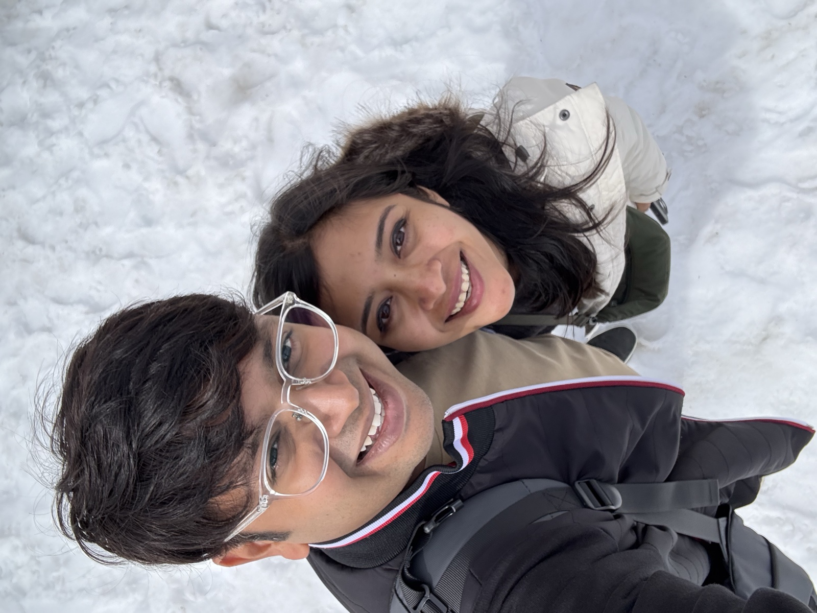 Priyam and Manish smiling for a selfie in the snow