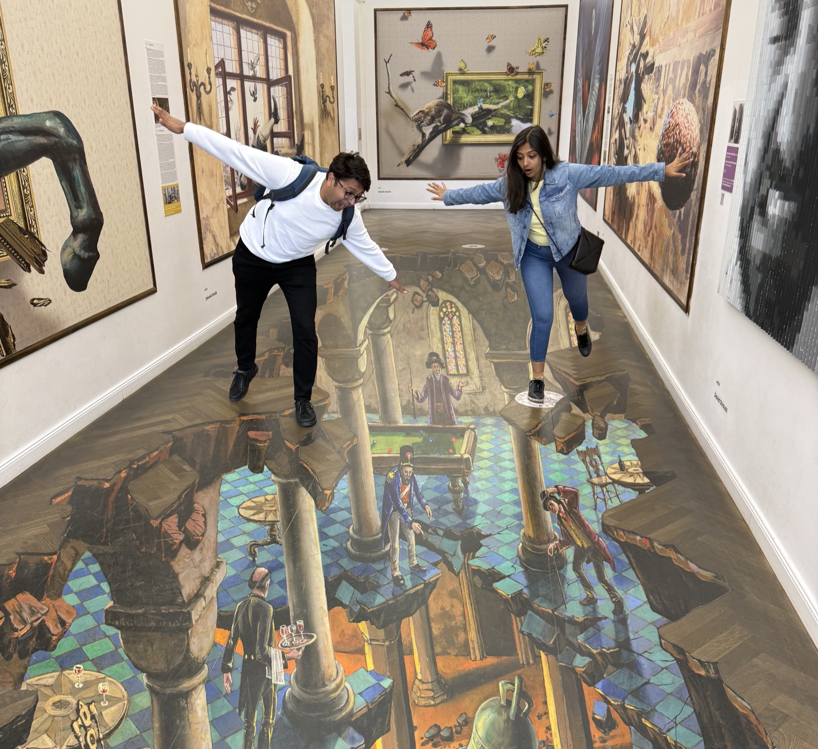 Priyam and Manish balancing playfully on an illusion-art floor